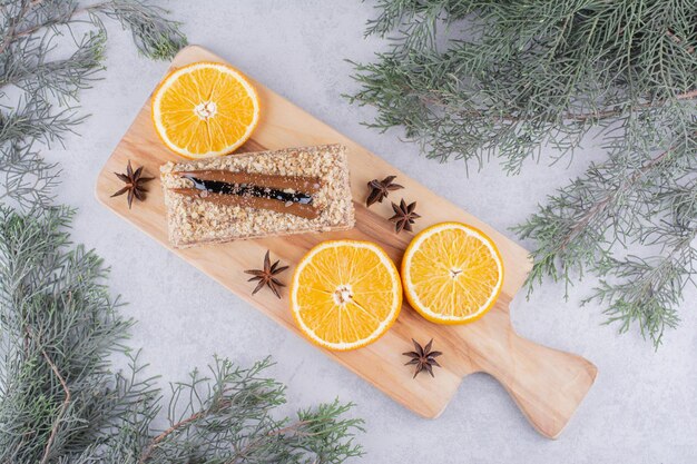 Hausgemachter Kuchen mit Nelken und Orangenscheiben auf Holzbrett.