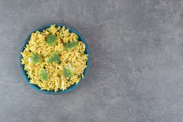 Hausgemachter Reis mit Brokkoli auf blauem Teller. Foto in hoher Qualität