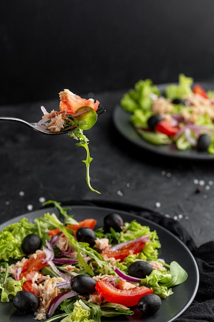 Hausgemachter Salat mit dunklem Geschirr