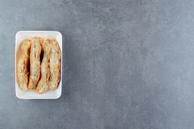 Hausgemachtes Gebäck mit Käse auf weißem Teller.