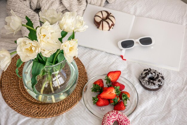 Hauskomposition mit einem Blumenstrauß aus Erdbeeren und Donuts