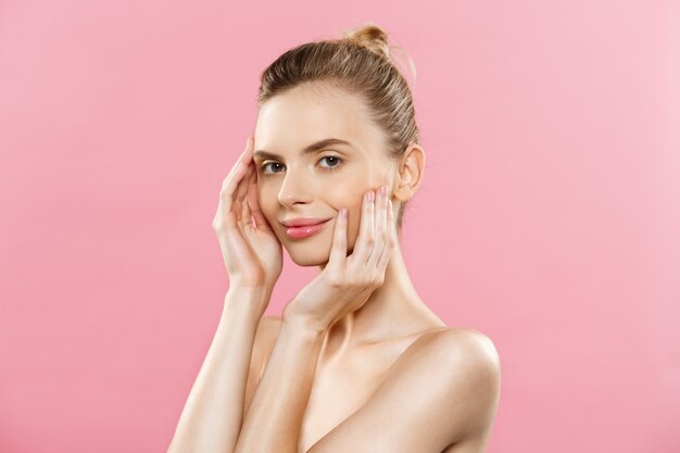 Hautpflege-Konzept - Charmante junge kaukasisch Frau mit perfekte Make-up Foto Zusammensetzung der Brünette Mädchen. Isoliert auf rosa Hintergrund mit Kopie Raum.