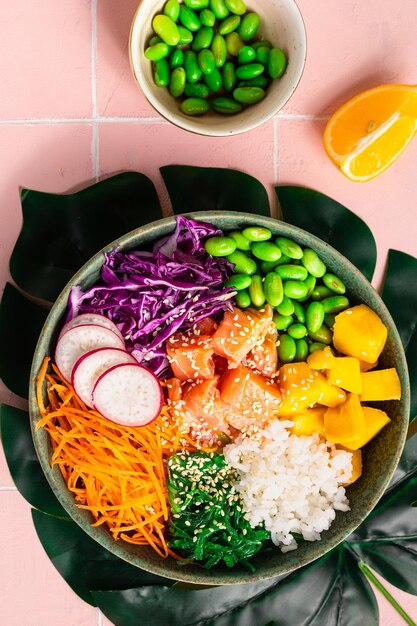 Hawaiian Poke Bowl mit Lachs in einer Schüssel mit Algen, Sesamsamen und Kohl Draufsicht flach vertikal liegend