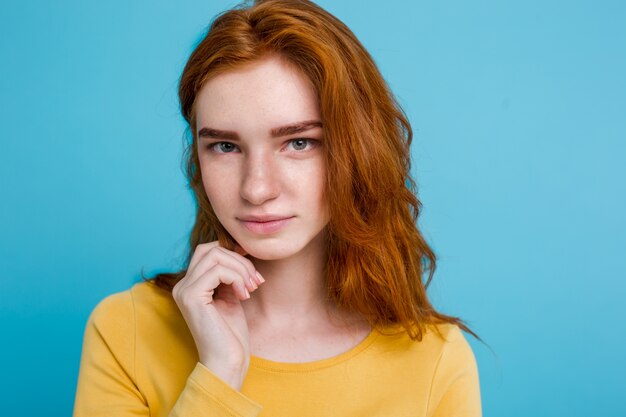 Headshot Portrait von glücklichen Ingwer rote Haare Mädchen mit Freckles lächelnd Blick in die Kamera. Pastell blauen Hintergrund. Text kopieren