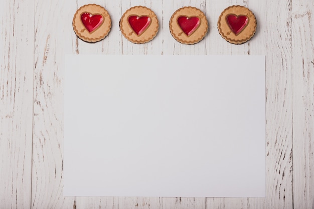 Kostenloses Foto heart-shaped cookies auf einem holztisch mit einem weißen papier