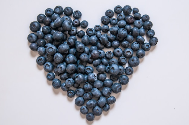 Heidelbeeren isoliert auf weißem Hintergrund. Blaubeergrenzentwurf. Reife und saftige frisch gepflückte Heidelbeeren close up. Copyspace Draufsicht oder flach liegen