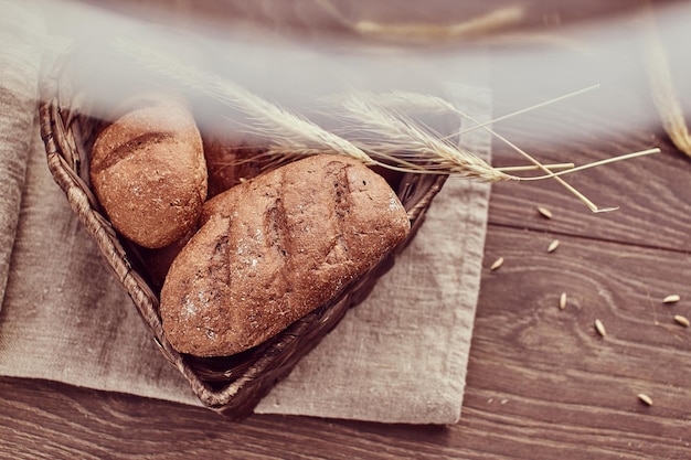 Heiße frische Brötchen in einem herzförmigen Korb. Nahaufnahme von frisch gebackenen Brotprodukten.