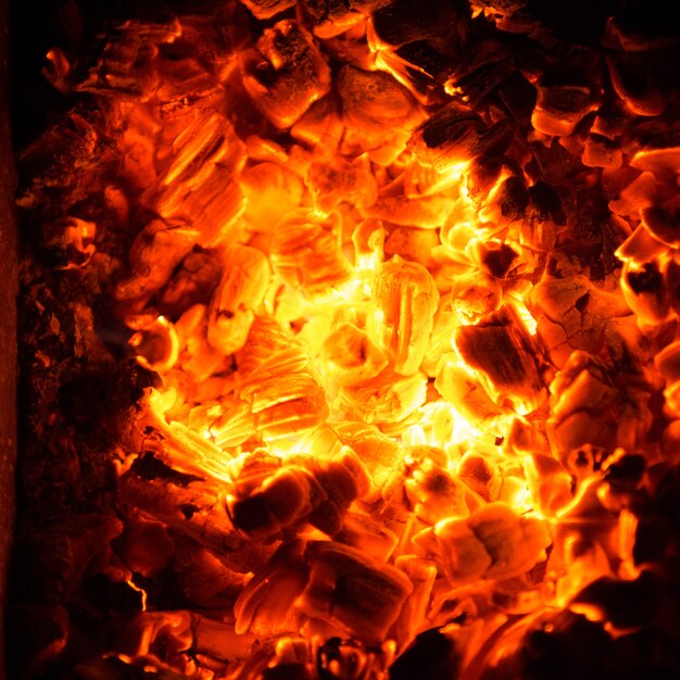 Heiße Kohlen im Feuer. Abstrakter Hintergrund der brennenden Glut.