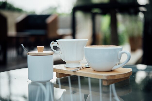 Heiße Lattekunst in der Kaffeetasse auf hölzerner Tabelle in der Kaffeestube