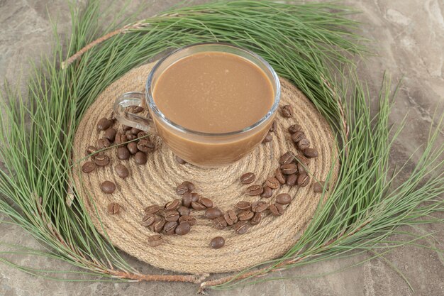 Kostenloses Foto heißer kaffee, kieferngras und kaffeebohnen auf holzstück