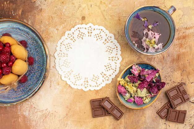 Heißer Kräutertee-Weichkuchen mit Fruchtblumenschokoriegeln und Serviette auf Mischfarbtabelle