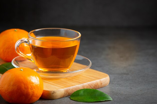 Heißer Orangentee und frische Orange auf dem Tisch