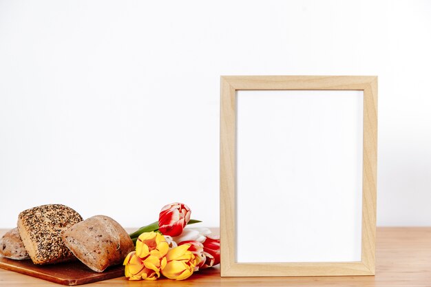 Helle Blumen mit Brötchen und Fotorahmen