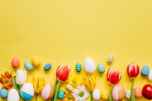 Kostenloses Foto helle farbige eier mit blumen auf gelb