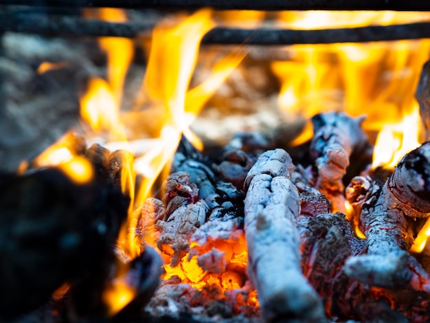 Helle Feuerflammen und schwelende Kohlen im Feuer