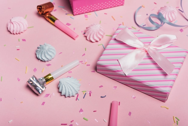 Heller Geburtstagshintergrund mit Süßigkeiten; Partygebläse und Geschenkbox