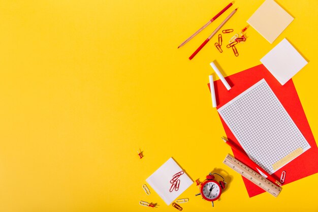 Heller Satz von Schulbriefpapier bestehend aus Rot und Papier, Klammern, Buntstiften, Bleistiften und Holzlineal