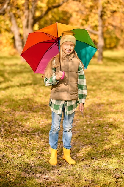Herbst. Ein Mädchen mit einem hellen Regenschirm in einem Herbstpark