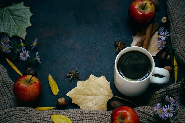 Herbst, Herbstlaub, heißer dampfender Kaffee und ein warmer Schal oder eine Strickjacke. Saison-, Morgenkaffee, Sonntag entspannend und Stilllebenkonzept.