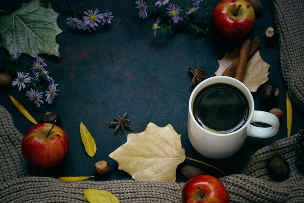 Herbst, Herbstlaub, heißer dampfender Kaffee und ein warmer Schal oder eine Strickjacke. Saison-, Morgenkaffee, Sonntag entspannend und Stilllebenkonzept.