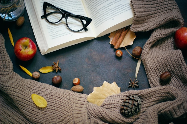 Herbst, Herbstlaub, heißer dampfender Kaffee und ein warmer Schal oder eine Strickjacke. Saison-, Morgenkaffee, Sonntag entspannend und Stilllebenkonzept.