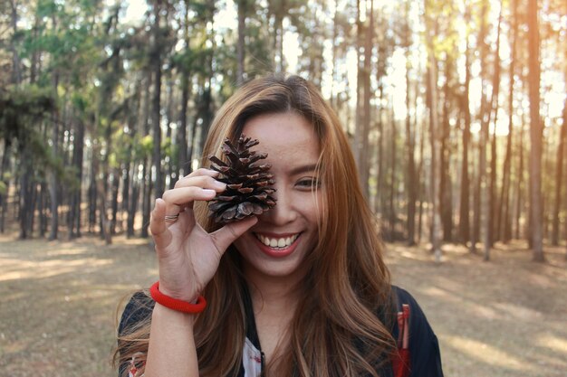 Herbst Mode Leben Stil Konzept. Schöne junge Frau zu Fuß in Pinienwald.