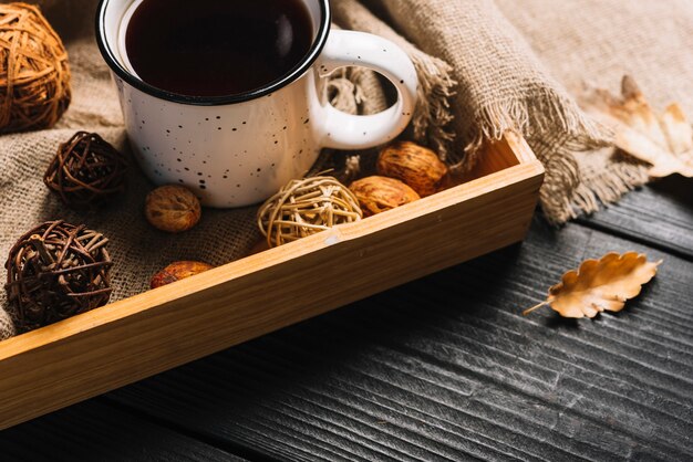 Herbstblatt nahe Behälter mit Becher und Dekorationen