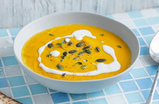 Herbstliche Suppe in Schüssel auf grauem Hintergrund