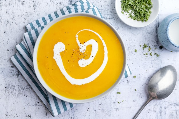 Herbstliche Suppe in Schüssel auf grauem Hintergrund