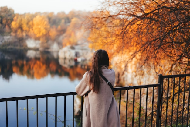 Herbstmädchen, das rückwärts steht und Natur aufpasst.