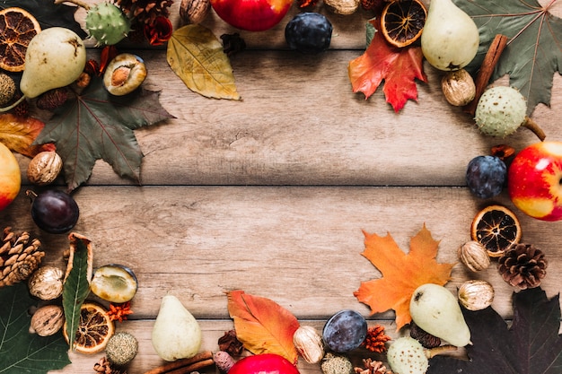 Kostenloses Foto herbstrahmenzusammensetzung mit ernte auf hölzernem hintergrund