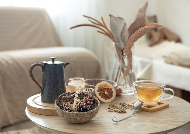 Herbststillleben mit Tee auf dem Tisch im Inneren des Raumes, Kopienraum.