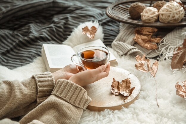 Herbststilllebenmädchen, das eine Tasse Tee hält.