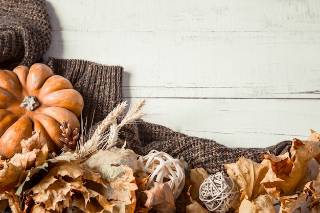 Herbstwand mit Dekorationsgegenständen und Kürbis.