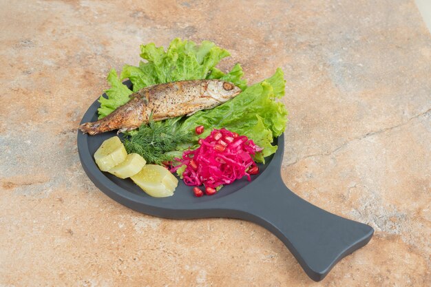 Kostenloses Foto hering mit salat und rotkohl auf holzbrett