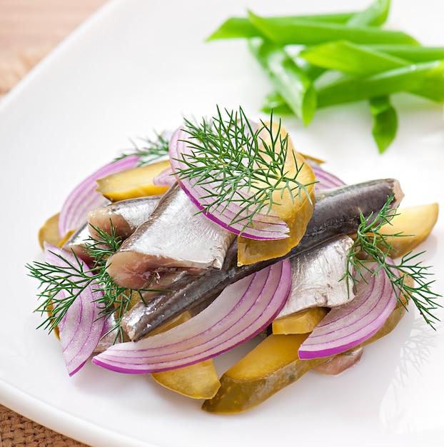 Kostenloses Foto heringsalat mit eingelegten gurken und zwiebeln