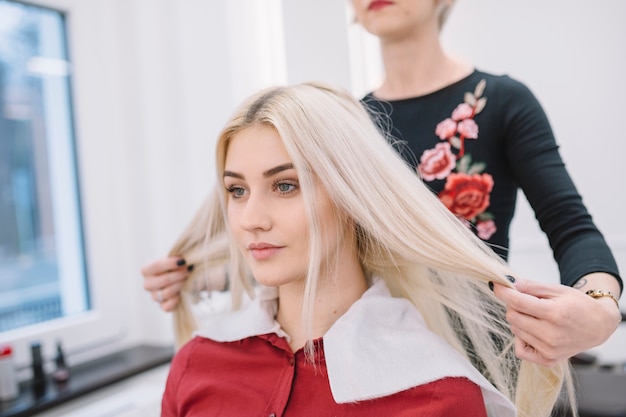 Herrenfriseur, der mit Blondine im Salon arbeitet