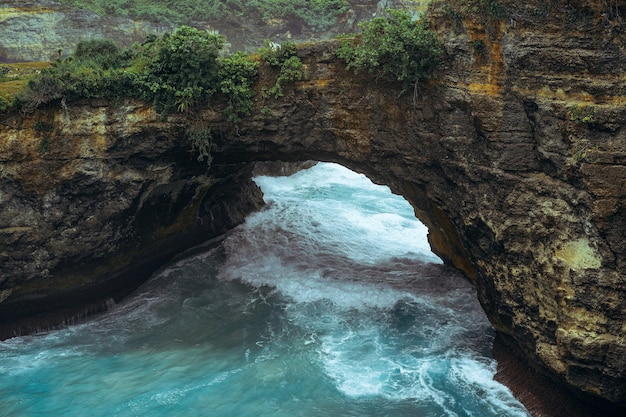 Herrlicher Blick auf einzigartige natürliche Felsen und Klippen in einem wunderschönen Strand, der als Angel's Billabong Beach bekannt ist und sich auf der Ostseite der Insel Nusa Penida, Bali, Indonesien, befindet. Luftaufnahme.