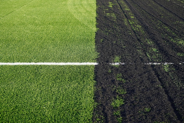 Herstellung eines Kunstrasen-Fußballplatzes mit grüner Kunstrasenoberfläche und Gummigranulat