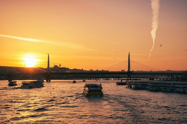 Hervorragender gelber Sonnenuntergang der fliegenden Möwen und Boote des türkischen Meeres, die über schwimmen