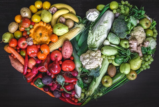 Herz aus frischem Gemüse und Obst auf Holzhintergrund