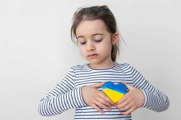 Herz in den Farben der Flagge der Ukraine in Kinderhänden gemalt