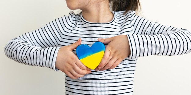 Herz in den Farben der Flagge der Ukraine in Kinderhänden gemalt