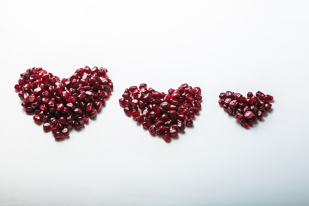 Herzen formen granatapfelkerne auf weiß.