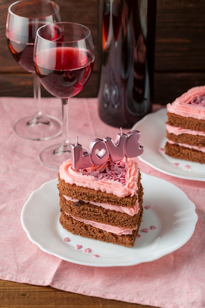 Herzförmige Kuchenscheibe mit Weingläsern und Kerzen