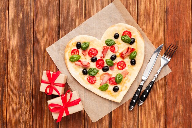 Herzförmige Pizza der Draufsicht mit Geschenken