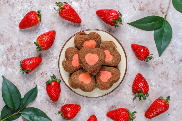 Herzförmige Schokoladen- und Erdbeerplätzchen mit frischen Erdbeeren, Draufsicht