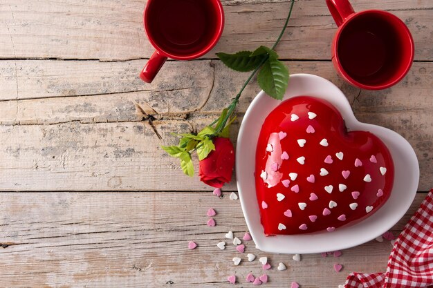 Herzförmiger Kuchen zum Valentinstag oder Muttertag auf Holztisch
