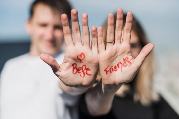 Herzform und Text der besten Freunde auf der Hand des Paares