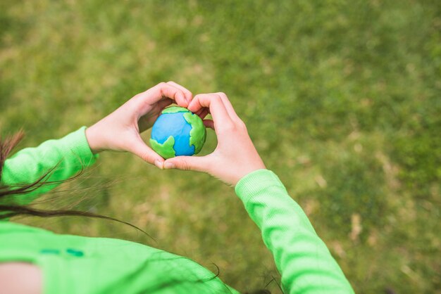 Herzformhände umgibt den bunten Plasticineplaneten